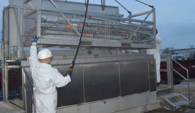 REYM-Kollege lässt Gitterkiste mit Ihnalt in Ultraschallreinigungsanlage ab
