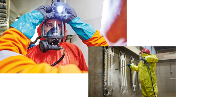 1. REYM-Kollege unterstützt beim korrekten Anlegen der PSA mit Atemschutzmaske und Stirnlampe. 2. REYM-Kollege in PSA bei der Wasserhochdruckreinigung.